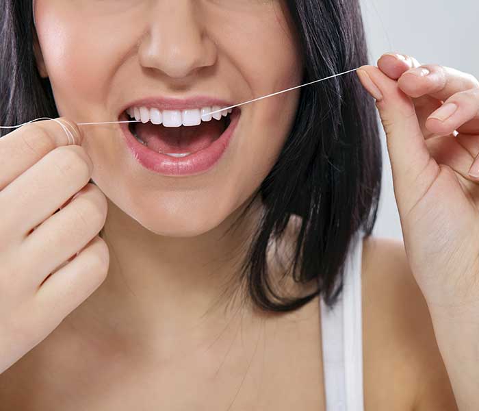 A woman flossing her teeth