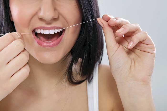 A woman flossing her teeth