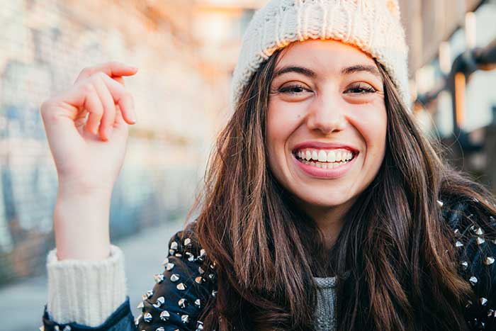 A girl wearing a woolen cap laughing