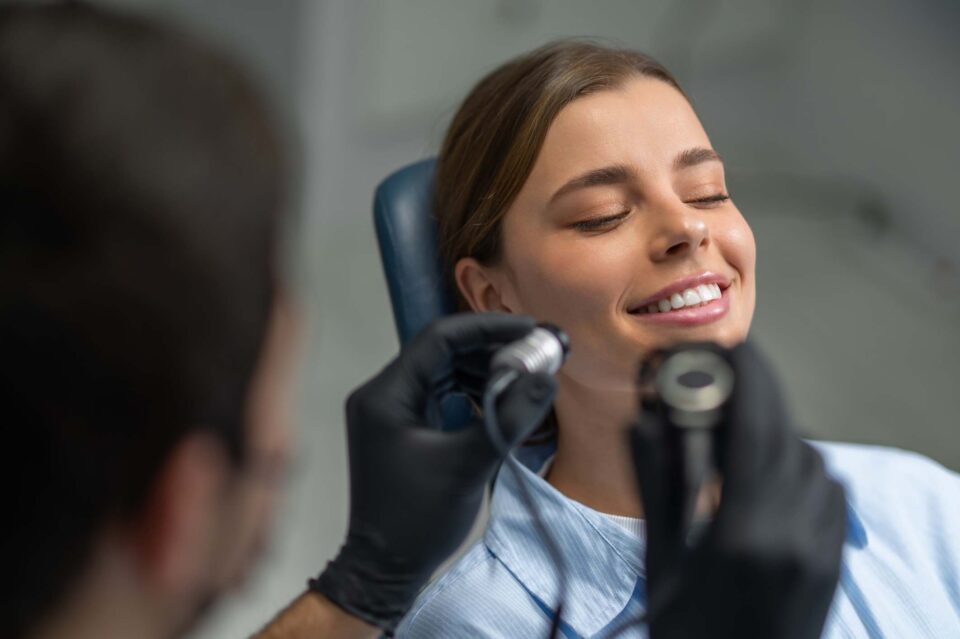 Dentist hands in gloves holding intraoral camera for teeth inspection closeup